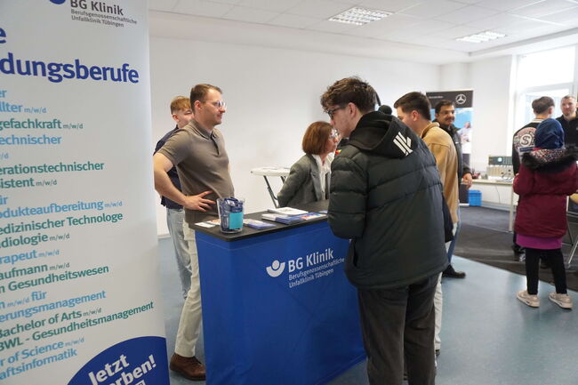 Besucher informieren sich an einem Stand der BG Klinik Tübingen über Ausbildungsberufe.