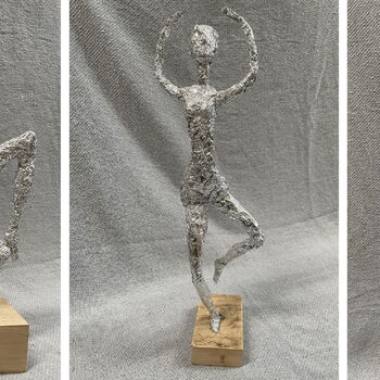 Drei kunstvolle Figuren aus Aluminiumfolie zeigen ausdrucksstarke Tanzposen auf Holzsockeln vor einem grauen Hintergrund.