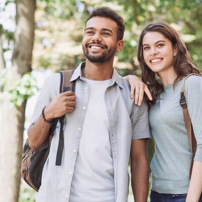 Ein junger Mann und eine junge Frau blicken lächelnd in die Ferne
