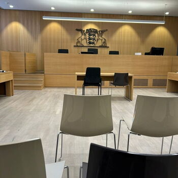 Ein leerer Gerichtssaal mit Holzverkleidung und Stühlen, bereit für die nächste Anhörung im Amtsgericht. | © Name