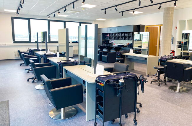 Ein moderner Friseurraum mit eleganten Stühlen und Spiegeln, bereit für kreative Haarschnitte.