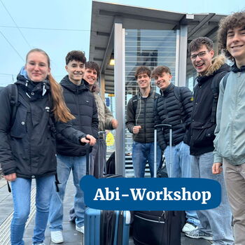 Eine Gruppe von jungen Leuten steht am Bahnhof mit Gepäck und lächelt begeistert für den Abi-Workshop.