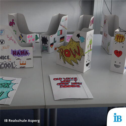 Bunt gestaltete Papierständer mit kreativen Slogans schmücken einen Tisch beim Schulfest der Realschule Asperg.
