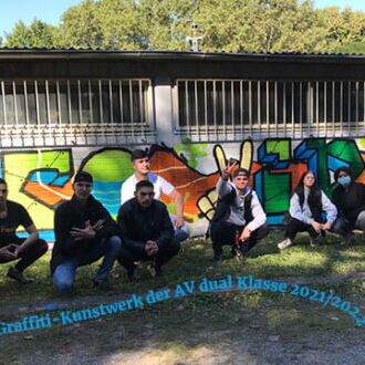 Eine Gruppe junger Menschen posiert vor einer bunten Graffiti-Wand bei einem Workshop im Freien.