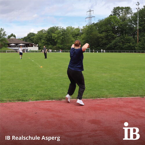 Eine Person bereitet sich auf einen Wurf beim Bundesjugendspiele-Event auf einem Sportplatz vor.