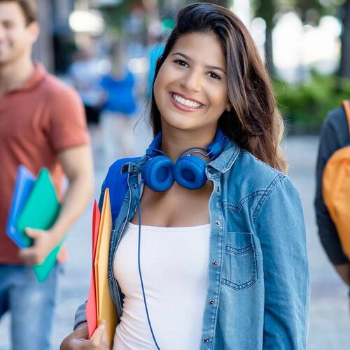 Schülerin der IB Schulen mit blauen Kopfhörern lächelt