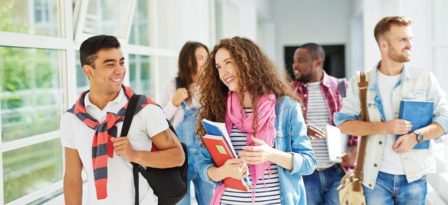 Schüler:innen gehen gemeinsam durch einen Flur