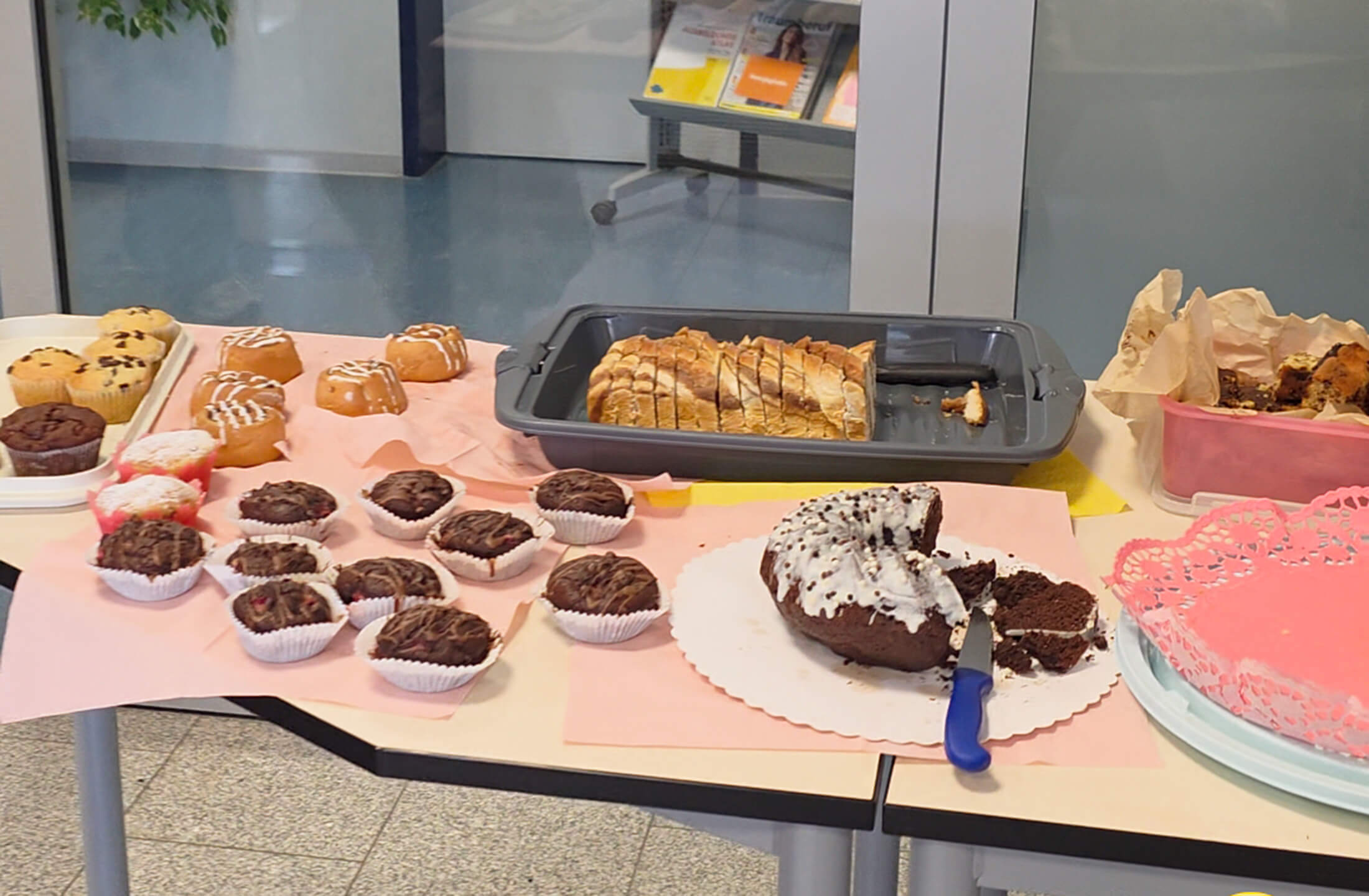 Eine bunte Auswahl an Kuchen und Muffins wird auf einem Tisch während des "Tag der offenen Tür" präsentiert.