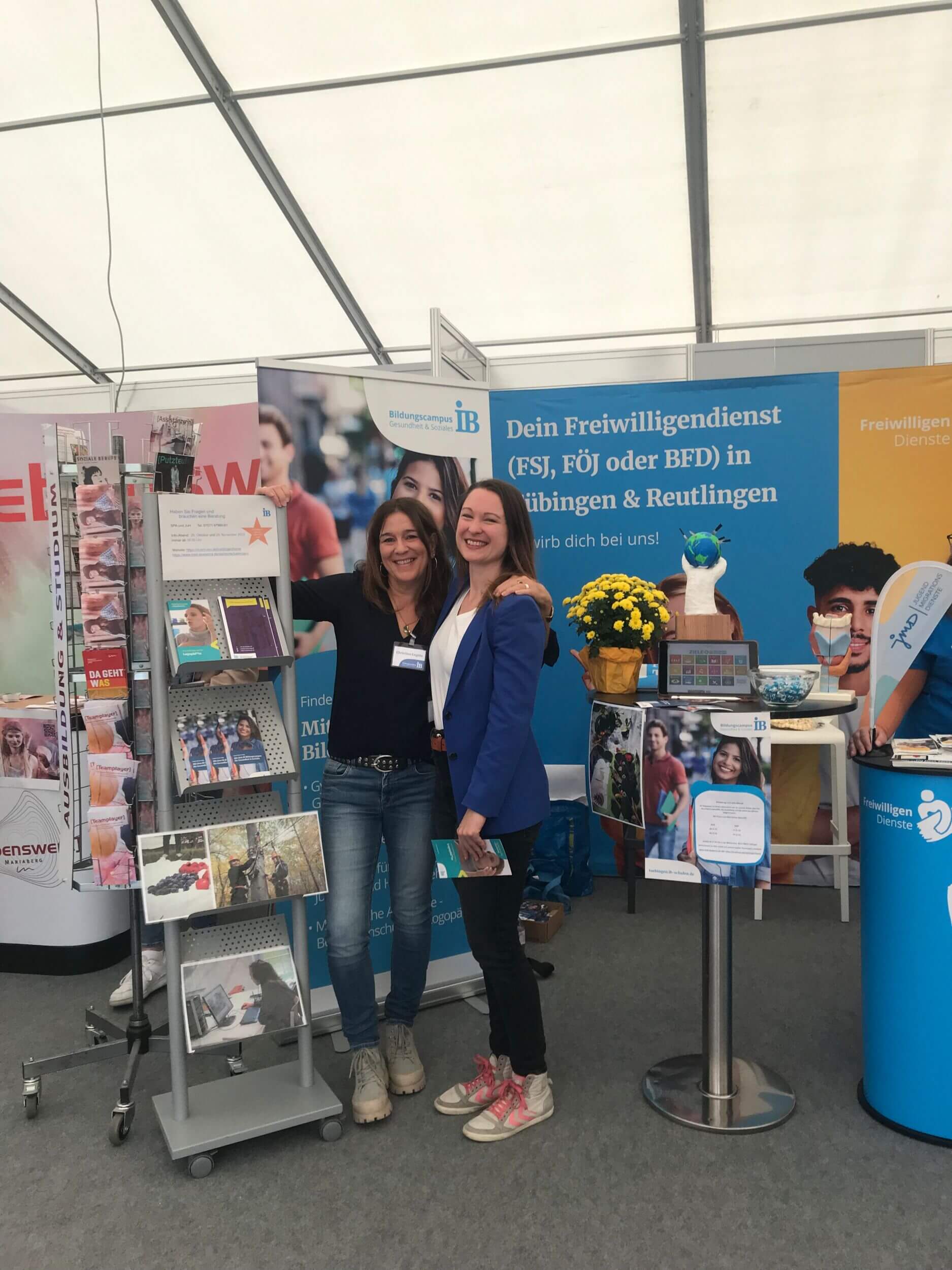 Zwei Frauen stehen lächelnd an einem Informationsstand über Freiwilligendienst in Tübingen und Reutlingen.