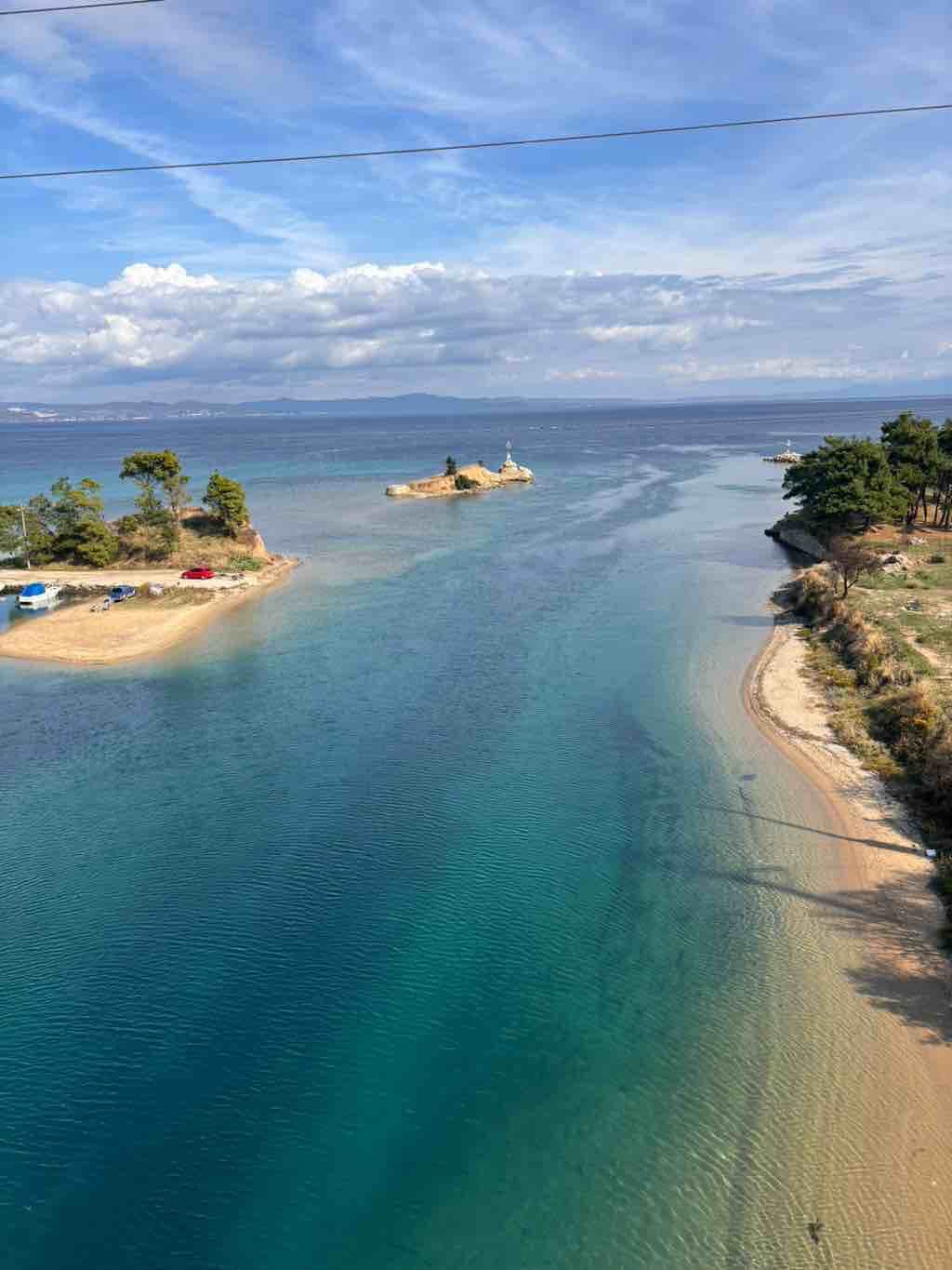 Klares Wasser und kleine Inseln unter blauem Himmel in der Nähe von Thessaloniki bieten eine malerische Küstenlandschaft.