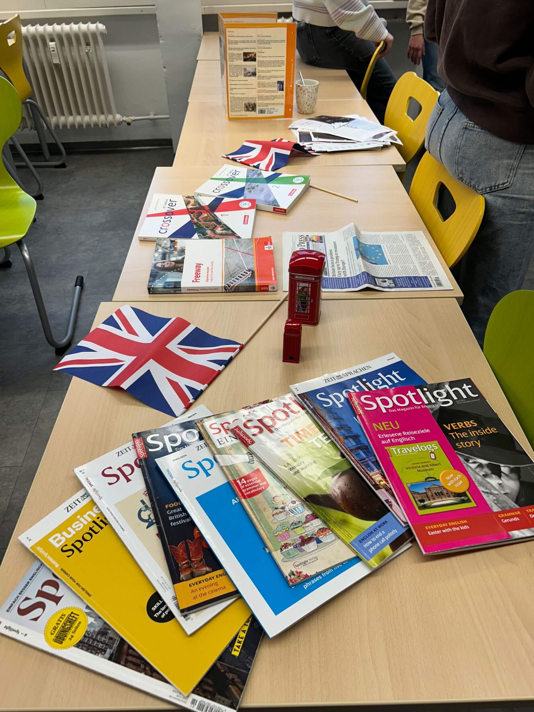 Ein Tisch ist mit englischen Zeitschriften, Union Jack-Fähnchen und einer roten Telefonzelle dekoriert.